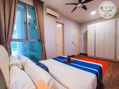a bedroom with a large bed and a ceiling fan at Puteri Harbour by RR JBcity in Nusajaya