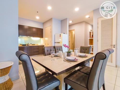 a dining room and kitchen with a table and chairs at Puteri Harbour by RR JBcity in Nusajaya
