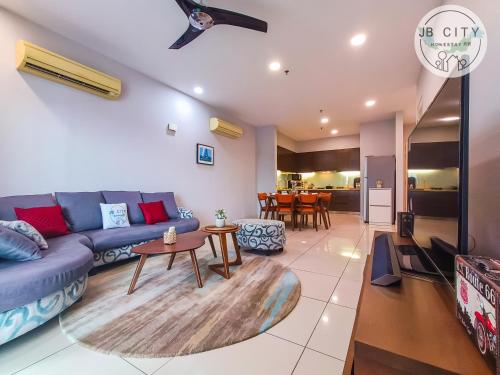 a living room with a blue couch and a table at Puteri Harbour by RR JBcity in Nusajaya