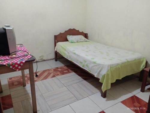 a small bedroom with a bed and a table at La 5ta in Iquitos