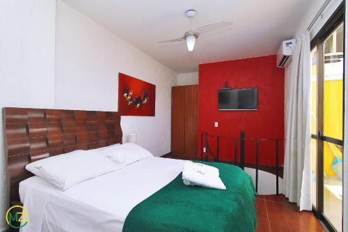 - une chambre dotée d'un lit avec un mur rouge dans l'établissement Linda Cobertura duplex com varanda e piscina, à Rio de Janeiro