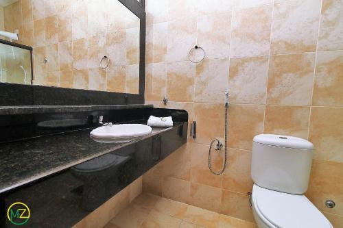 La salle de bains est pourvue de toilettes, d'un lavabo et d'un miroir. dans l'établissement Linda Cobertura duplex com varanda e piscina, à Rio de Janeiro