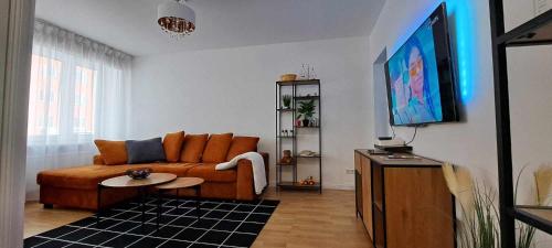 a living room with a couch and a tv at J. Kuperjanov Apartment in Tartu