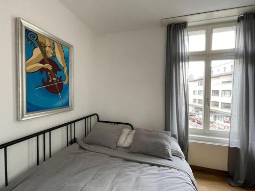 1 dormitorio con cama y ventana en Central City - inkl Parking and Bern Ticket en Berna