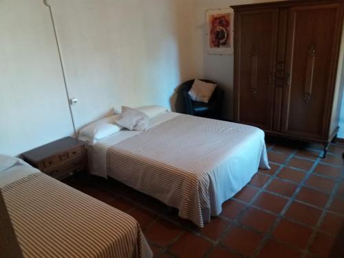 um quarto de hotel com duas camas e uma cadeira em Casa Rural en pleno paraje natural La Chirala em Enguera