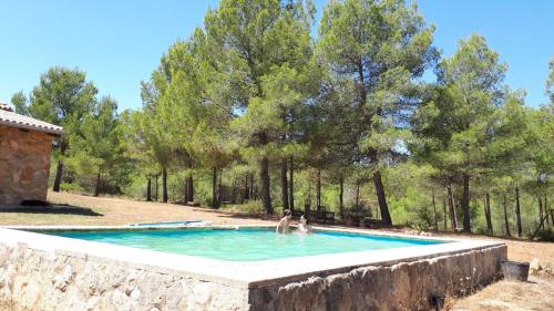 een paar mensen in een zwembad bij Casa Rural en pleno paraje natural La Chirala in Enguera