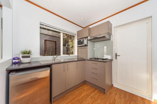 a kitchen with a sink and a counter top at Romantic Piha in Piha