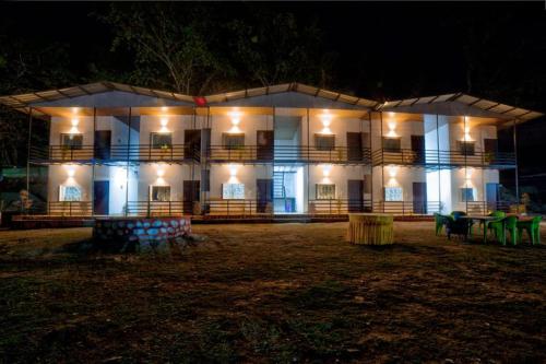 un gran edificio con luces encendidas por la noche en Chill stops Rishikesh titos, en Bijni