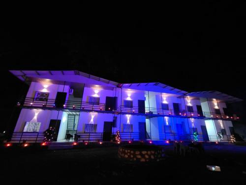 un edificio con luces azules por la noche en Chill stops Rishikesh titos, en Bijni