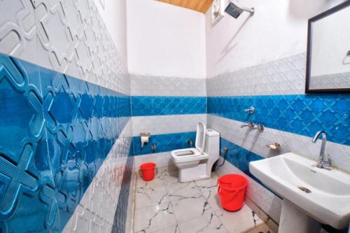 baño azul y blanco con aseo y lavamanos en Chill stops Rishikesh titos, en Bijni