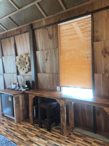 a room with a wooden table and a window at The Tropical Koh Mook in Koh Mook