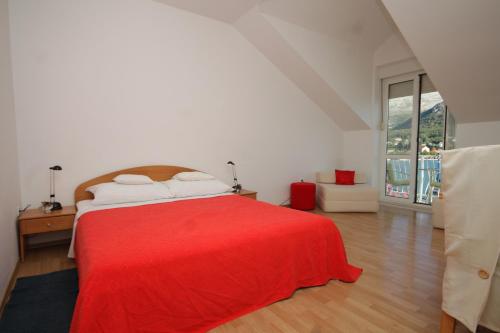 a bedroom with a red bed with a red blanket at Apartments by the sea Slano, Dubrovnik - 8538 in Slano