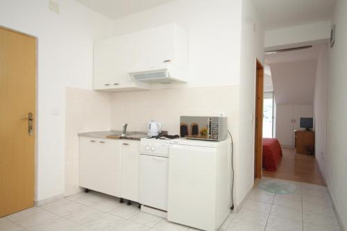 a white kitchen with a stove and a refrigerator at Apartments by the sea Slano, Dubrovnik - 8538 in Slano