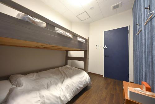 a bedroom with two bunk beds and a desk at 4S STAY Awaikeda ikedaonsenyoko in Miyoshi