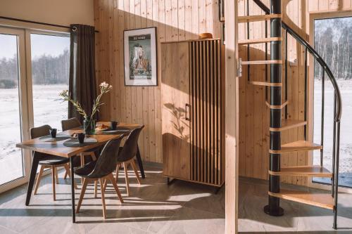 a dining room with a table and a spiral staircase at Zielone Wzgórze komfortowy klimatyzowany domek z balią z aeromasażem in Kłodzko