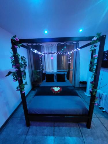 a bedroom with a bed with lights on it at Jacuzzi Love room appartement Proche Paris in Rosny-sous-Bois