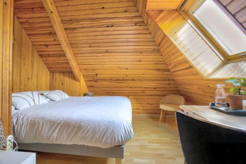 - une chambre avec un lit dans un grenier en bois dans l'établissement Louisette - Vue mer à moins de 1km de la plage, à Erquy