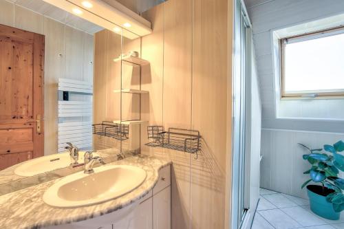 une salle de bain avec un lavabo et un miroir dans l'établissement Louisette - Vue mer à moins de 1km de la plage, à Erquy