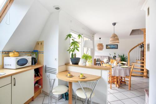 une cuisine et un salon avec une table et des chaises dans l'établissement Louisette - Vue mer à moins de 1km de la plage, à Erquy