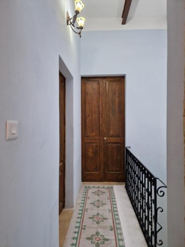 pasillo con puerta de madera y alfombra en Sir Patrick's rooms & hostel, en Għajn il-Kbira
