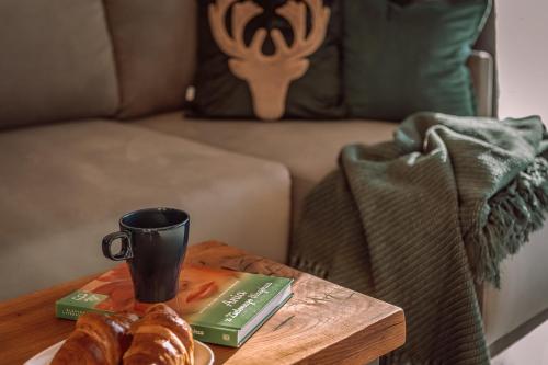 a coffee table with a coffee cup and croissants on it at Zielone Wzgórze komfortowy klimatyzowany domek z balią z aeromasażem in Kłodzko