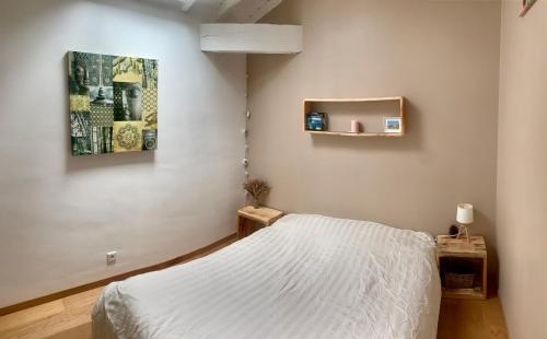 a bedroom with a bed and a painting on the wall at La Kasa Poza in Biaudos