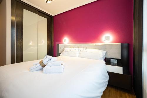 Un dormitorio con una cama blanca con toallas. en Casa Nerai Apartamento, en Gijón