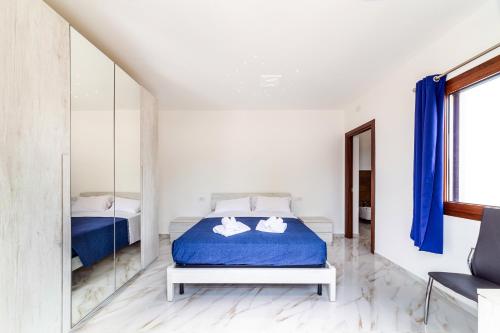 a bedroom with a bed with blue sheets and a mirror at Agriturismo La Croisette in Dorgali