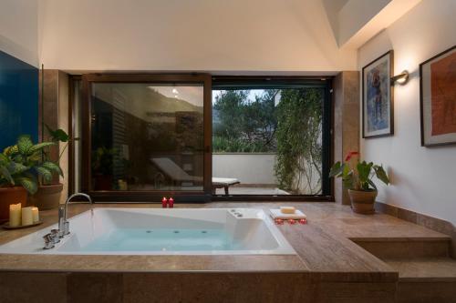 uma casa de banho com uma banheira e uma janela grande em Drage em Prgomet