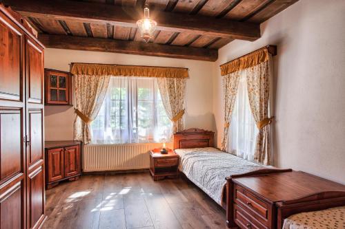 Schlafzimmer mit einem Bett, einem Tisch und einem Fenster in der Unterkunft Drevenica v Hybe in Hyby