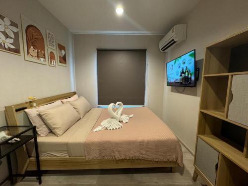 ein kleines Zimmer mit einem Bett mit einem Schwan darauf in der Unterkunft Near central westgate at bangyai 80 in Ban Bang Krabu