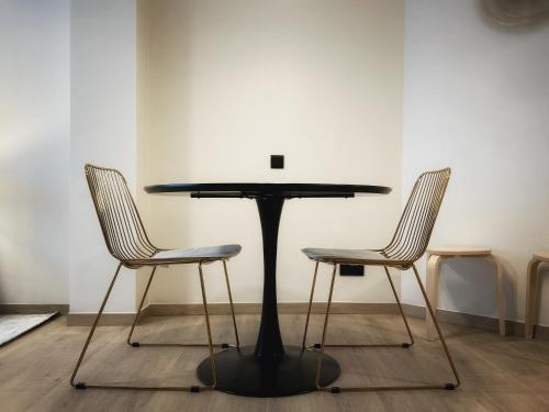 a black table and two chairs in a room at Suite luxueuse aux Guillemins in Liège