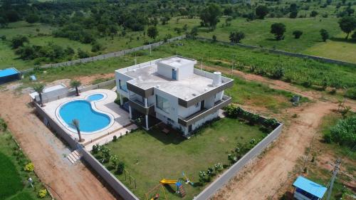 einen Luftblick auf ein großes Haus mit einem Pool in der Unterkunft Jha Farm & resorts 
