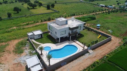 eine Luftansicht eines Hauses mit Pool in der Unterkunft Jha Farm & resorts 