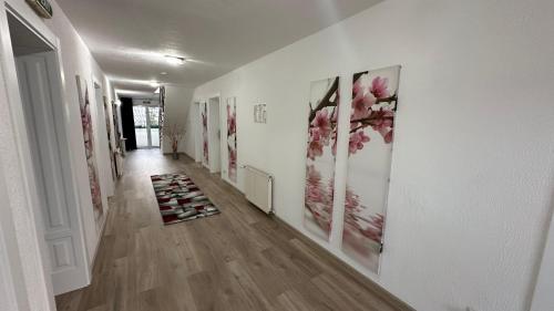 a hallway with paintings of flowers on the walls at Casa Augsburg in Băneşti