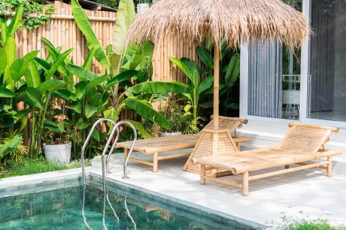 two chairs and a hammock next to a swimming pool at White Villa Ubud in Ubud