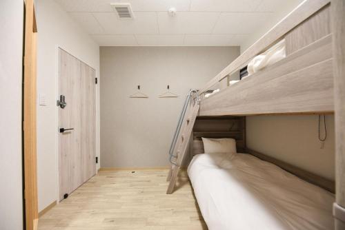 a room with two bunk beds and a staircase at 4S STAY Awaikeda ikedaonsenyoko in Miyoshi