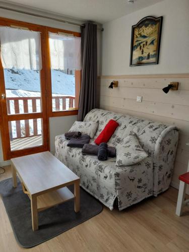 - un salon avec un canapé et un oreiller rouge dans l'établissement La Plagne Les Coches studio divisible ensoleillé, à La Plagne Tarentaise
