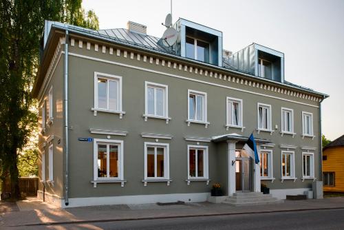 a gray building with white windows on a street at Pühajärve tee Kodu in Otepää