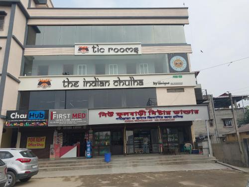 Un edificio con un reloj encima. en TIC ROOMS, en Siliguri