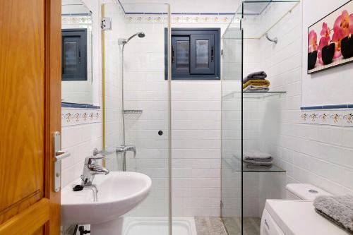 y baño con lavabo y ducha acristalada. en Apartamento Cabo en Caleta de Sebo