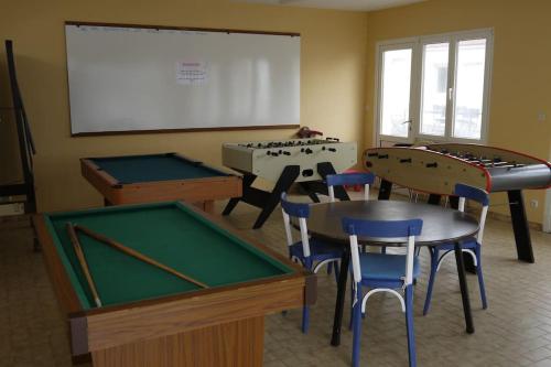 une salle de classe avec des billards, des chaises et un tableau blanc dans l'établissement Appart : houedic : plein sud, front de mer, à La Bernerie-en-Retz
