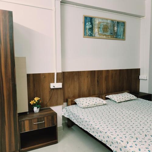 1 dormitorio con 1 cama y una foto en la pared en Nester Rooms, en Guwahati