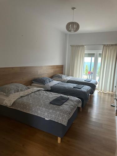fila de camas en una habitación con suelo de madera en Nowoczesne mieszkanie 65 m2, en Chojnice