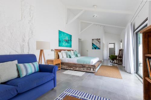 a living room with a bed and a blue couch at Charming 3-Bedroom Villa with Pool in Grand Baie in Grand Baie