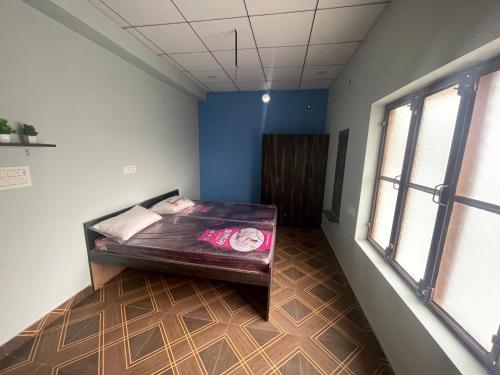 um quarto com uma cama num quarto com paredes azuis em Shiv shakti guest house em Bhiwāni
