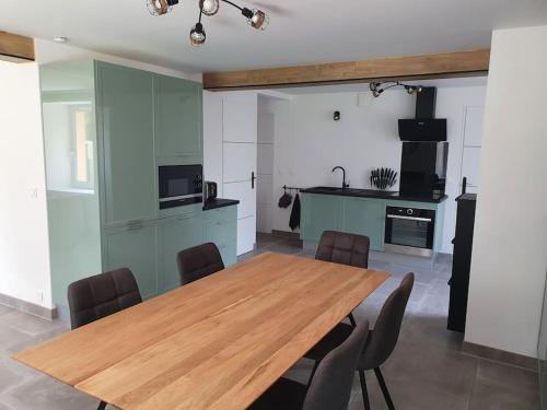 une salle à manger avec une table en bois et une cuisine dans l'établissement Rez de jardin 6 pers. Gérardmer, à Gérardmer