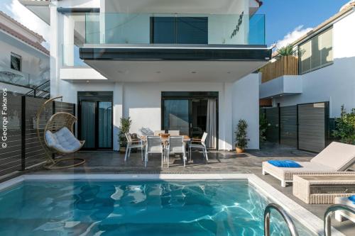 a house with a swimming pool and a patio at WHITE ROCK VILLAS LEFKADA in Lygia