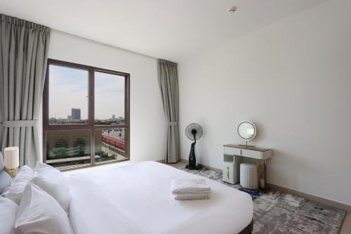 a bedroom with a white bed and a large window at Livbnb Suites - Madinat Jumeirah Living - Cozy 2 Bedroom near Burj Al Arab in Dubai