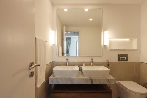 W łazience znajduje się umywalka, toaleta i lustro. w obiekcie Livbnb Suites - Madinat Jumeirah Living - Cozy 2 Bedroom near Burj Al Arab w Dubaju